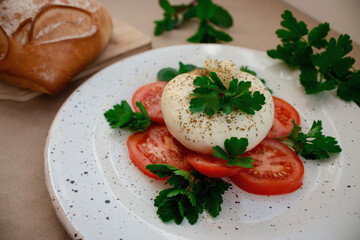 burrata cheese with tomato and herbs on a plate