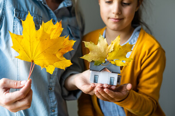 miniature house on the autumn leaves background. Concept of protecting or isolating house.