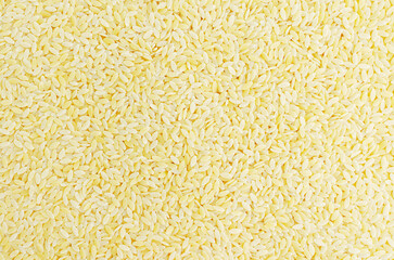 Raw risoni pasta with rosemary sprig. The concept of traditional Italian cuisine. Pattern. Horizontal orientation. Top view. copy space.