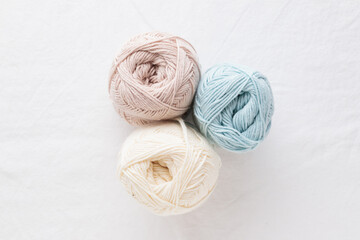 Balls of cotton yarn pastel colors on a white table