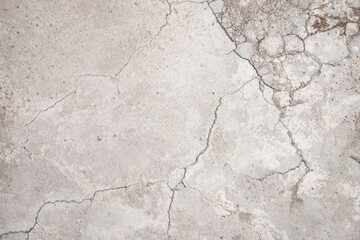 Piso de cemento color gris en plano cenital con desgaste y grietas por lo viejo. 