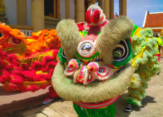 Chinese Lion dance street performances celebration in outdoor area at Thailand, focus at green lion head