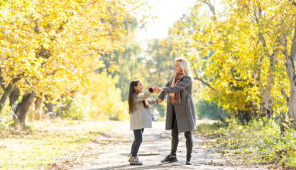 Obraz premium Mom with her daughter during autumn
