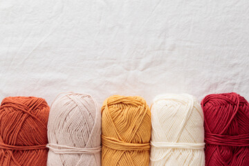 Balls of cotton yarn warm colors on a white table