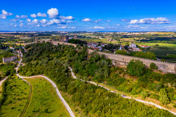 Aerial view of the historic walled town of Obidos at sunset, near Lisbon, Portugal. Aerial shot of Obidos Medieval Town, Portugal. Aerial view of medieval fortress in Obidos. Portugal.