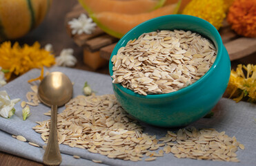 Edible dried raw organic seeds of musk melon or cantaloupe or tati or honeydew on a wooden surface.