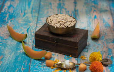 Edible dried raw organic seeds of musk melon or cantaloupe or tati or honeydew on a wooden surface.