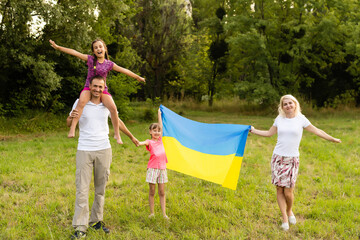 Fototapeta premium happy family with flag of ukraine in field. lifestyle