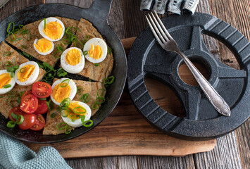 Fitness breakfast with homemade oatmeal pancake, boiled eggs, scallions and tomatoes