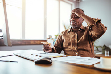 Serious African American man  in living room manage budget received invoice analyzes month expenses...