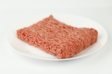 Ground beef on a white plate, fresh minced meat.