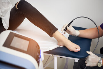 Feet laser therapy. Physiotherapist doctor uses Laser medical equipment for highly effective feet pain treat. Concept of medical orthopedic treatment and rehabilitation - 508240631