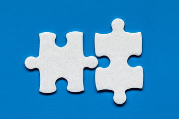Obraz premium White jigsaw puzzle. White puzzle pieces on color background. Unfinished white jigsaw puzzle pieces on color background.