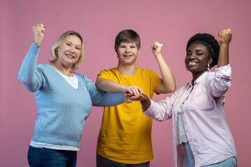 Guy and two women looking at camera with raised fists