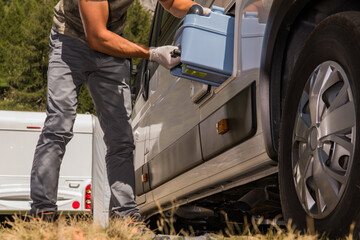Men Removing Toilet Cassette From His Camper Van RV