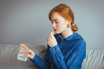 Close up image of woman putting white round pill in mouth. Sick female taking medicines,...