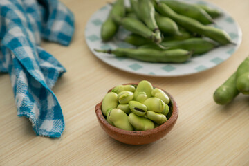fresh peeled and shelled broad beans on plates with copy space