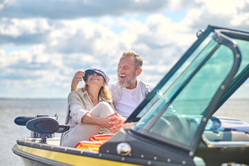 A happy mature couple sitting in the boat and hugging