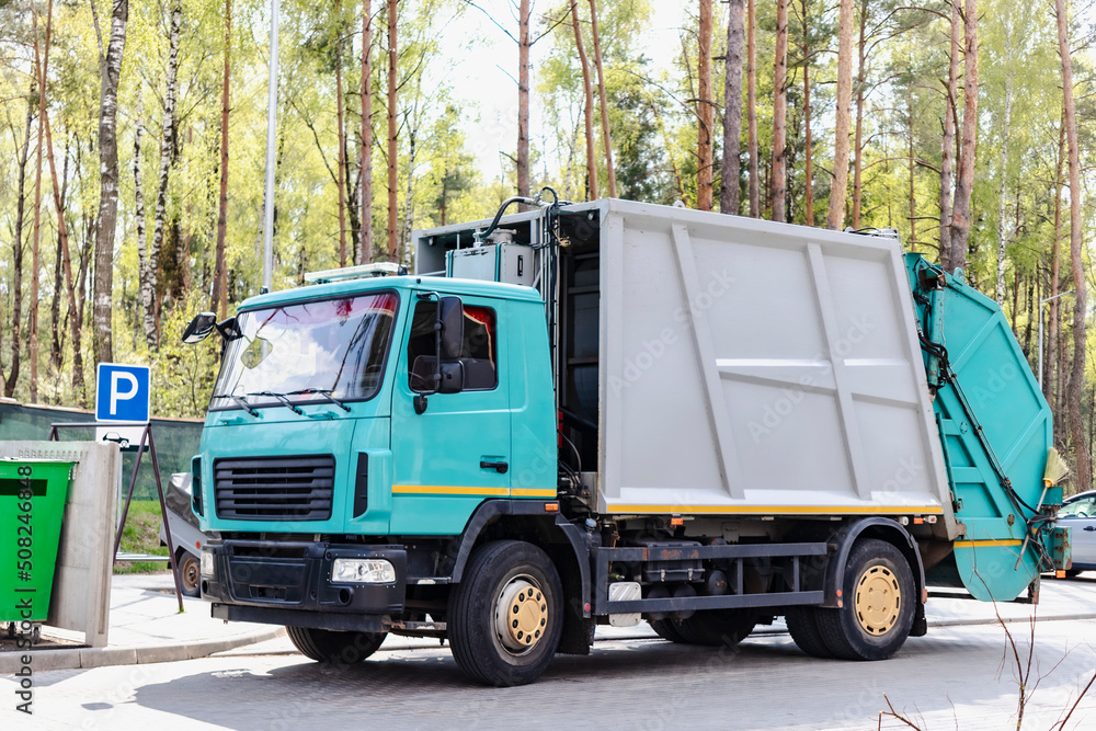 Aufkleber A garbage truck picks up garbage in a residential area. Loading mussar in containers into the car. Separate collection and disposal of garbage. Garbage collection vehicle.
