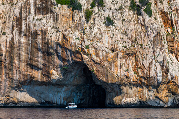 Blue sea and the characteristic caves of Cala Luna, a beach in the Golfo di Orosei, Sardinia, Italy. Big sea caves in the mediterranean coast. Sardinia, Italy.