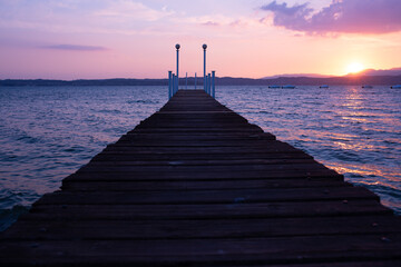 Fototapeta na wymiar Landing stage with bathing ladder in sirmione on lake garda at sunset.