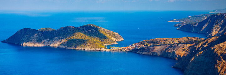 Fototapeta premium Assos village in Kefalonia, Greece. Turquoise colored bay in Mediterranean sea with beautiful colorful houses in Assos village in Kefalonia, Greece, Ionian island, Cephalonia, Assos village.