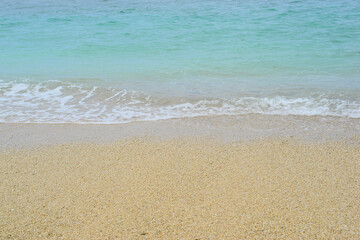Fototapeta na wymiar Beach sand background with small waves that produce wave foam