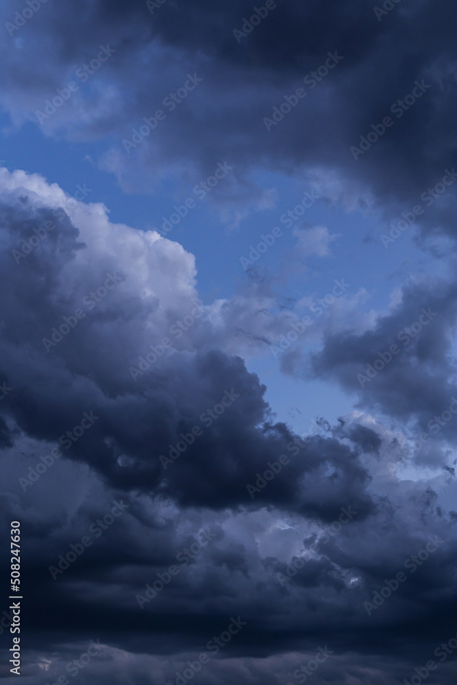 Wall mural epic dramatic storm dark grey cumulus rain clouds against blue sky background texture, thunderstorm