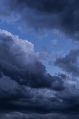 Epic Dramatic storm dark grey cumulus rain clouds against blue sky background texture, thunderstorm