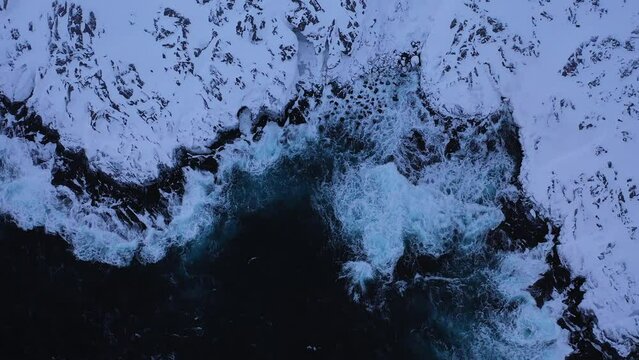 Above view of Barents sea coast in winter. Waves crashing on the rocky coast