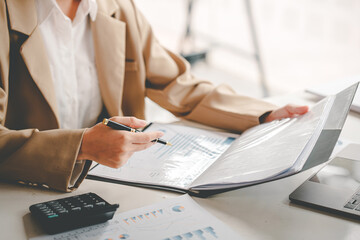 business woman or accountant who are using a calculator to calculate business data Accounting...