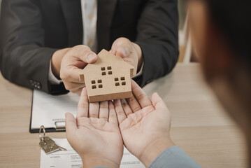 Realtor agent giving a key of apartment to new owner after signed lease agreement.