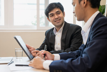 financial advisory services. Asian advisor showing plan of investment to clients in the consultancy office