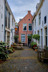 Obraz premium A peaceful cobbled alley with bicycles parked outside traditional houses. Springtime in Haarlem, Netherlands.