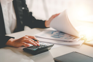 business woman or accountant who are using a calculator to calculate business data Accounting...