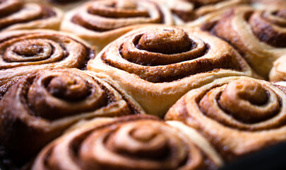 Fototapeta premium Freshly baked cinnabon buns. Homemade bakery. Traditional American dessert. Close-up. Selective focus.