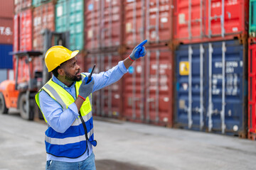 African man worker using walkie talkie to communication with colleague at container yard.
