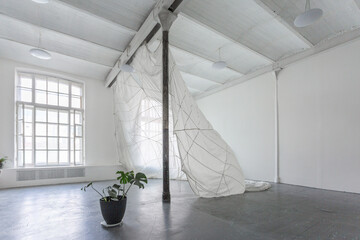 Art installation with a hanging parachute in the white spacious photo studio.