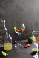 Preparation of lemonade from strawberries, lemon and fresh mint. Pieces of fruit and mint in a transparent glass