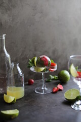 Preparation of lemonade from strawberries, lemon and fresh mint. Pieces of fruit and mint in a transparent glass