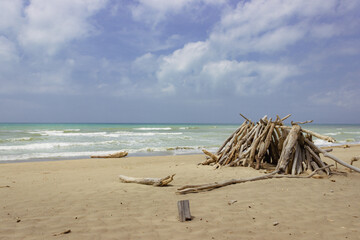 Marine landscape. Hut made from wooden logs on the beach. Scenic image.