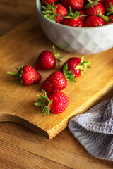 Sweet, ripe and fresh strawberries on a plate on the kitchen board