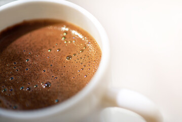 Cup of freshly brewed coffee with foam.