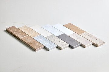 Porcelain ceramic stoneware samples laid on kitchen stoneware table as examples of future kitchen fasade and counertop exterior. Stoneware exhibitor for finishing of kitchen countertops and surfaces
