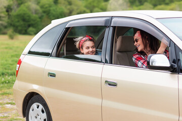 Vacation and trip. Happy mother and daughter drives in a rented car. The concept of purchase a new car