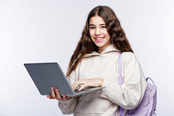 Naklejka premium Teenage girl looking at her laptop, getting ready for school and finishing homework