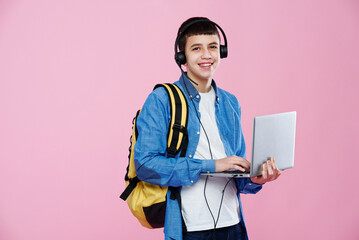 Young teenage boy using his laptop, working on his school work or taking an online class