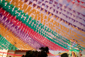 decoração junina com bandeirinhas coloridas e roda-gigante no entorno da igreja