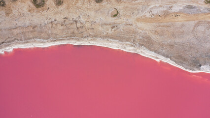 Flying over a pink salt lake. Salt production facilities saline evaporation pond fields in the...