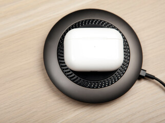 image of earphones charging wooden background 